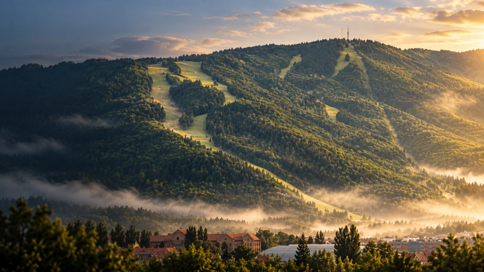 Mariborsko Pohorje z gozdnatimi pobočji in smučarskimi posekami v jutranji svetlobi